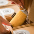 Yellow product in a cardboard box with a hand interacting with it